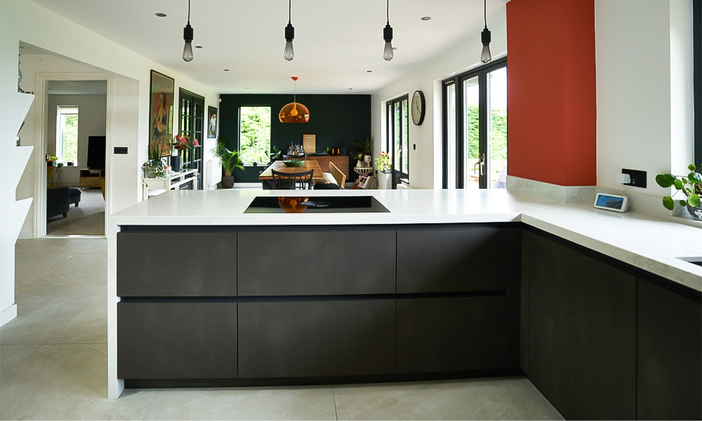 A close-up view of an L-shaped kitchen featuring deep lacquered cabinetry with a white marble countertop. The dark, glossy finish of the cabinets creates a striking contrast with the light, elegant marble surface. The design highlights the clean lines and modern aesthetic, with the white marble adding a touch of luxury and brightness to the space. This layout emphasizes both style and functionality, making the kitchen ideal for efficient meal preparation and a welcoming atmosphere.