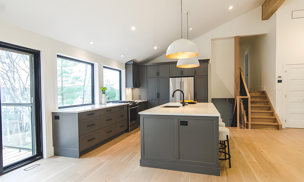 A modern kitchen featuring dark gray lacquered cabinetry and a central island. The deep, rich gray of the cabinets creates a sophisticated, bold look, while the island serves as both a functional workspace and a stylish focal point in the sleek, contemporary design.