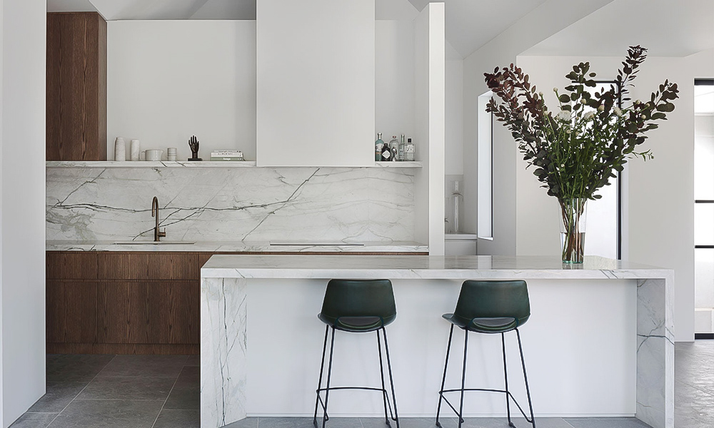 A one-wall kitchen featuring white lacquered upper cabinets and wood veneer lower cabinets, complemented by a central island. The combination of bright white and natural wood tones creates a harmonious, modern look, with the island serving as both a functional workspace and a stylish focal point.