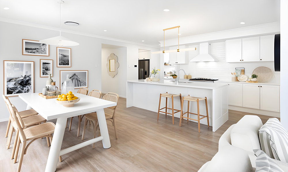 A one-wall kitchen featuring white lacquered cabinetry and a central island. The glossy white finish of the cabinets creates a bright, clean aesthetic, while the island adds both functionality and a modern focal point to the open layout.