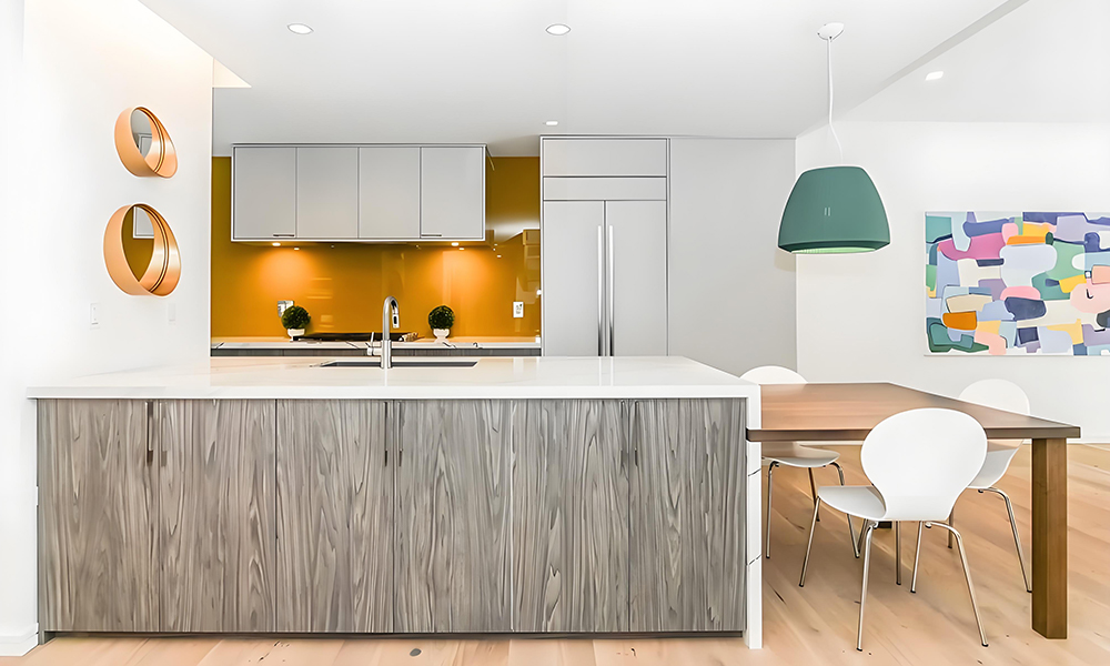 A modern kitchen featuring white cabinetry and a matching white island, creating a bright and airy atmosphere. The clean, minimalist design emphasizes the sleek, uniform look of the white finishes, enhancing the spacious and contemporary feel of the kitchen.
