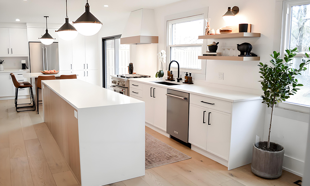 A modern kitchen featuring white cabinetry in a sleek one-wall layout, complemented by a central island. The white finish of the cabinets creates a clean and airy atmosphere, while the central island offers both additional counter space and a functional focal point. The design emphasizes simplicity and elegance, with a minimalist approach that enhances the spacious and inviting feel of the kitchen. The modern styling is perfect for creating a contemporary, streamlined cooking and dining space.